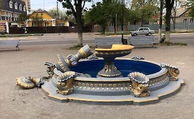 Под Киевом девушка с ребенком на плечах забралась на верхушку фонтана