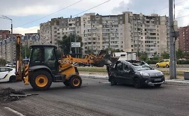 В Киеве трактор снес ковшом крышу легковому авто