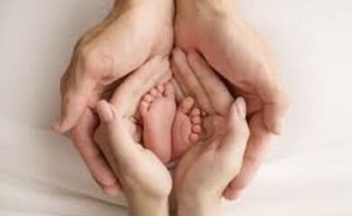 Детские ножки в ладонях родителей