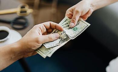 Человек передает доллары, иллюстративное фото