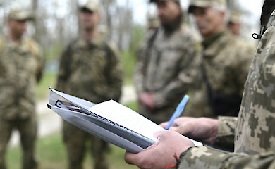 Мужчина в военной форме заполняет документы, иллюстративное фото