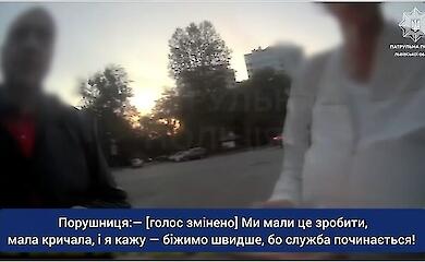 Семья с детьми пересекает многополосную городскую дорогу, за ними наблюдает патрульный